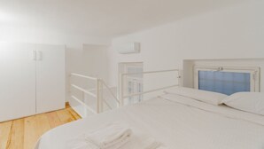 A bedroom with a bed, white wardrobe, and a window with a view. - GuestHost - Modern mezzanine studio apartment of 30 m2, ideal for two people, located on the raised ground floor of a typical Milanese building (stairs to access the apartment).The property is located a stone's throw from the M1 Lima stop in a strategi (Milan)