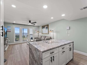 A spacious kitchen with a marble island, a ceiling fan, and a view to the outside. - Cute Waterfront Condo, Water Views, Heated Pool (Port Charlotte)