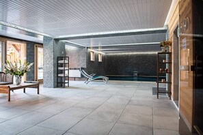 Ein großzügiger Innenbereich mit Pool, Sitzgelegenheiten und einer Rezeption.