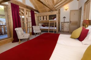 Ein Zimmer mit einem Etagenbett, einem roten Teppich, einem Holzstuhl und einem Vorhangfenster.