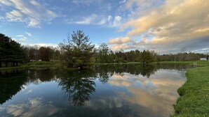 Ein ruhiger See mit Spiegelungen von Bäumen und einem klaren Himmel.