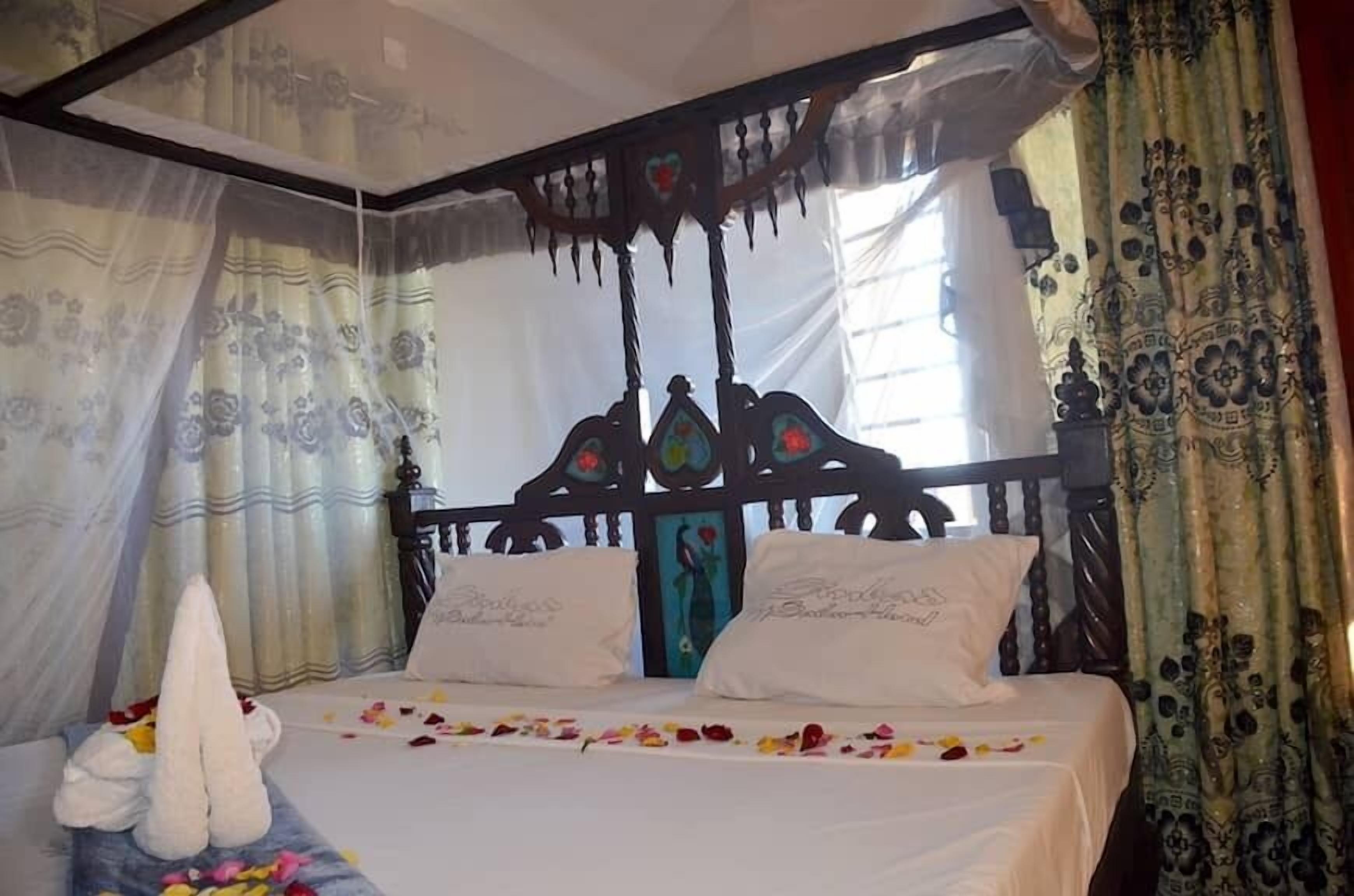 Uma cama de dossel com cortinas florais e um toldo.