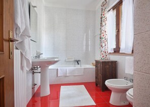 A bathroom with a white sink, a bathtub, a toilet, and a shower area. - Luna Apartment (sleeps 4) (Rivoli veronese)