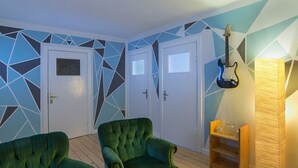 Ett rum med två gröna fåtöljer, en gitarr och en lampa.