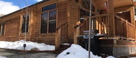 A wooden cabin with a porch and a stone pathway.