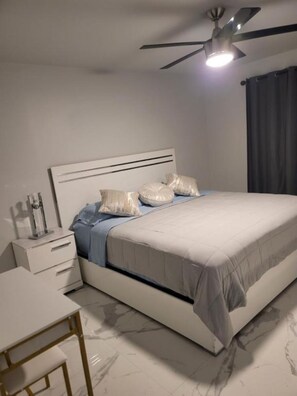A modern bedroom with a bed, bedside table, and a desk. - Stylish 3BR Pool Home Villa Frankely! (TAMPA)