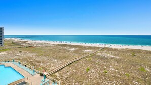 A beach view with a swimming pool, beach chairs, and a boardwalk. - Island Pass OB • Steps to Beach • In the Heart of OB • Fully Loaded • Bunk Room (Orange Beach)