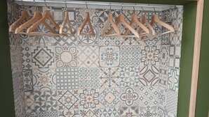 Une pièce avec un mur orné de motifs, une étagère en bois et un appareil électronique noir.