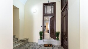 Ein Flur mit Treppe, einer Holztür und einer Fußmatte.