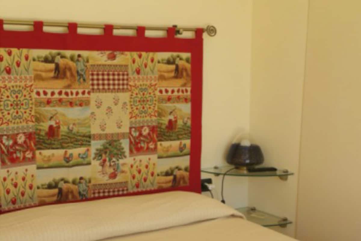 A bed with a quilted headboard featuring a patchwork design.