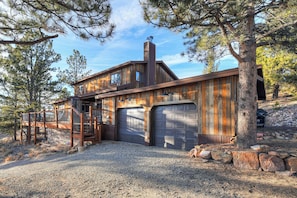 A rustic cabin with a wooden exterior, a stone foundation, and a gravel driveway. - Spacious Valley View Lodge - Huge deck! (Fairplay)
