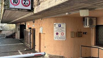 Entrada de un estacionamiento con señal de límite de velocidad, letrero de estacionamiento privado y zona de prohibido estacionar.