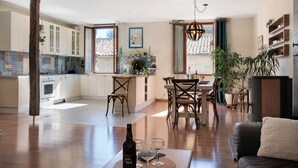A spacious kitchen with a dining area, wooden cabinets, and a large window.