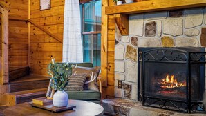 A cozy interior with a stone fireplace, wooden walls, and a comfortable seating area. - Fresh Design! Creekside Cabin, Hot Tub, Dollywood! (Sevierville)