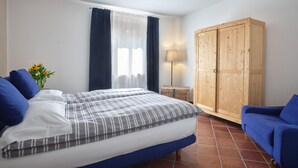 A bedroom with a bed, a wardrobe, a lamp, and a blue sofa. - Apartment for 6 people (RIVOLI VERONESE)