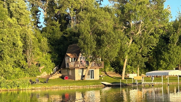 A lakeside cabin with a deck and a small dock.