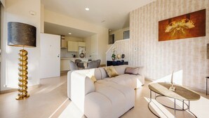 A modern living room with a sectional sofa, a coffee table, and a unique floor lamp. - Casa d'Oro neart Vistabella Golf (Orihuela)