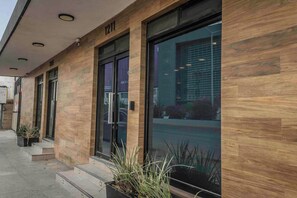A building with a modern facade, large glass windows, and a number '1211' on the wall. - Hotel Victoria Monterrey (Monterrey)