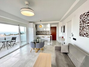 Un appartement moderne doté d’un balcon, d’un coin repas, d’une cuisine et d’un salon.
