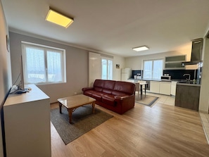 Um apartamento moderno com sala de estar, cozinha e espaço para refeições.
