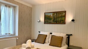 A neatly made bed with a brown blanket, two pillows, and a set of towels. - Welcome to Montmélian, a Savoyard Town Nestled in the Heart of the Combe de Savoie! (Montmélian)