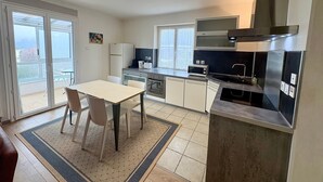 A modern kitchen with a dining area, a refrigerator, a microwave, a stove, and a large window. - Welcome to Montmélian, a Savoyard Town Nestled in the Heart of the Combe de Savoie! (Montmélian)