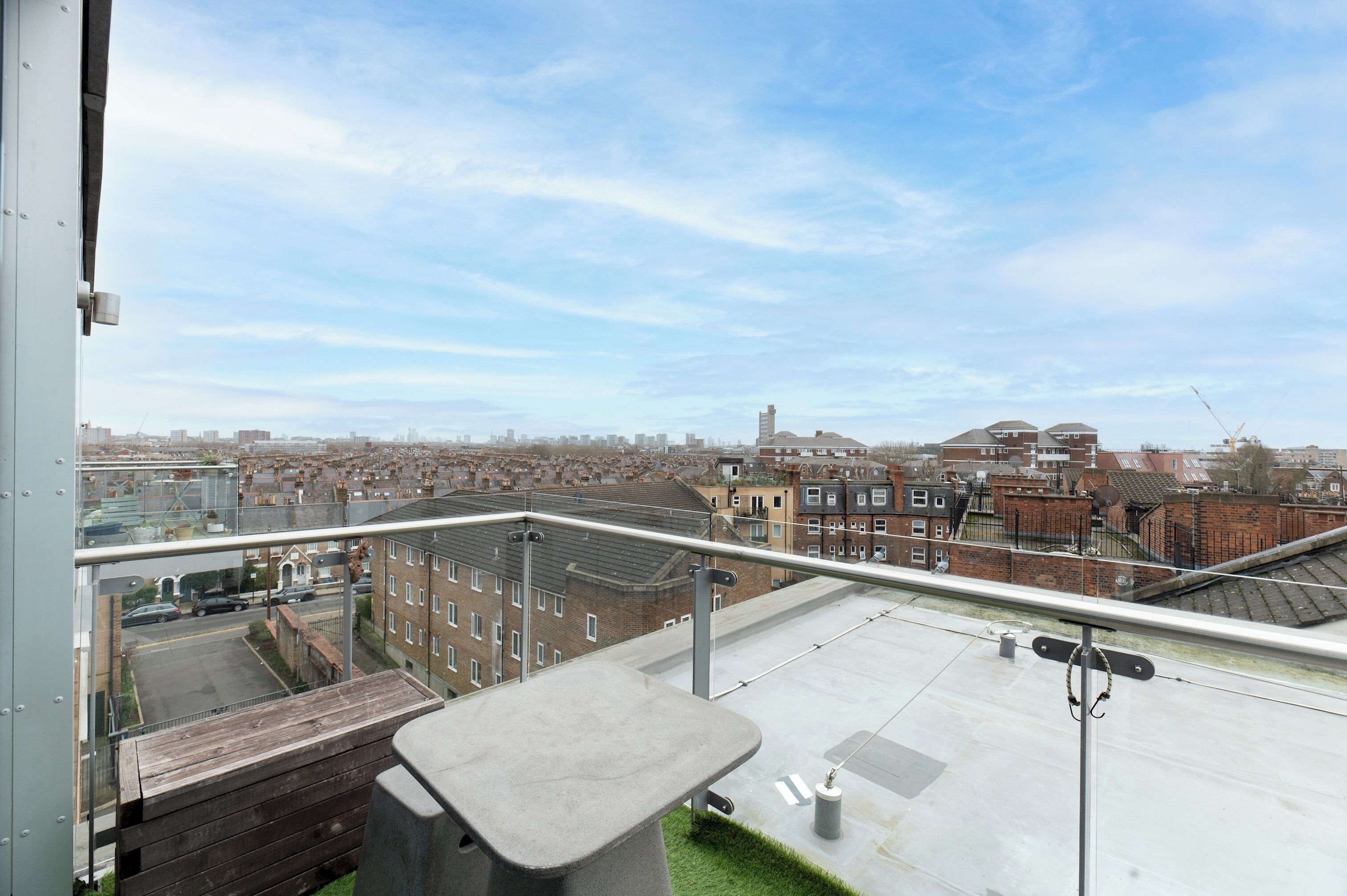 En balkon med udsigt over byens skyline, der viser en blanding af bolig- og erhvervsbygninger.