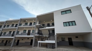A multi-story residential building with balconies and a gated entrance.