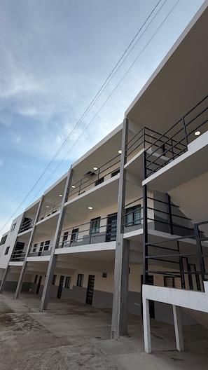 A multi-story building with a modern architectural design, featuring balconies and large windows.