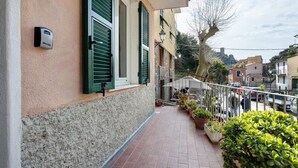 Ein Balkon mit Blumentöpfen, einer Sicherheitsvorrichtung und Blick auf die Straße.