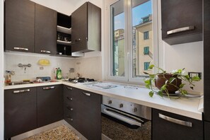 Une cuisine moderne avec des meubles de couleur sombre, une fenêtre et une plante en pot.