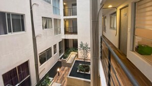 A multi-level residential building with balconies, a central courtyard, and a view of the surrounding area. - Apartment with modern design (Ciudad de México)
