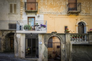 Un edifici amb un balcó, una porta i una reixa.