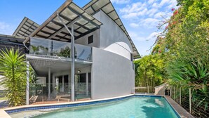 A modern house with a swimming pool, large glass windows, and a covered outdoor area. - Family-sized Retreat With Private Garage (Brisbane)