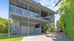A modern two-story house with a flat roof, large windows, and a covered balcony. - Family-sized Retreat With Private Garage (Brisbane)