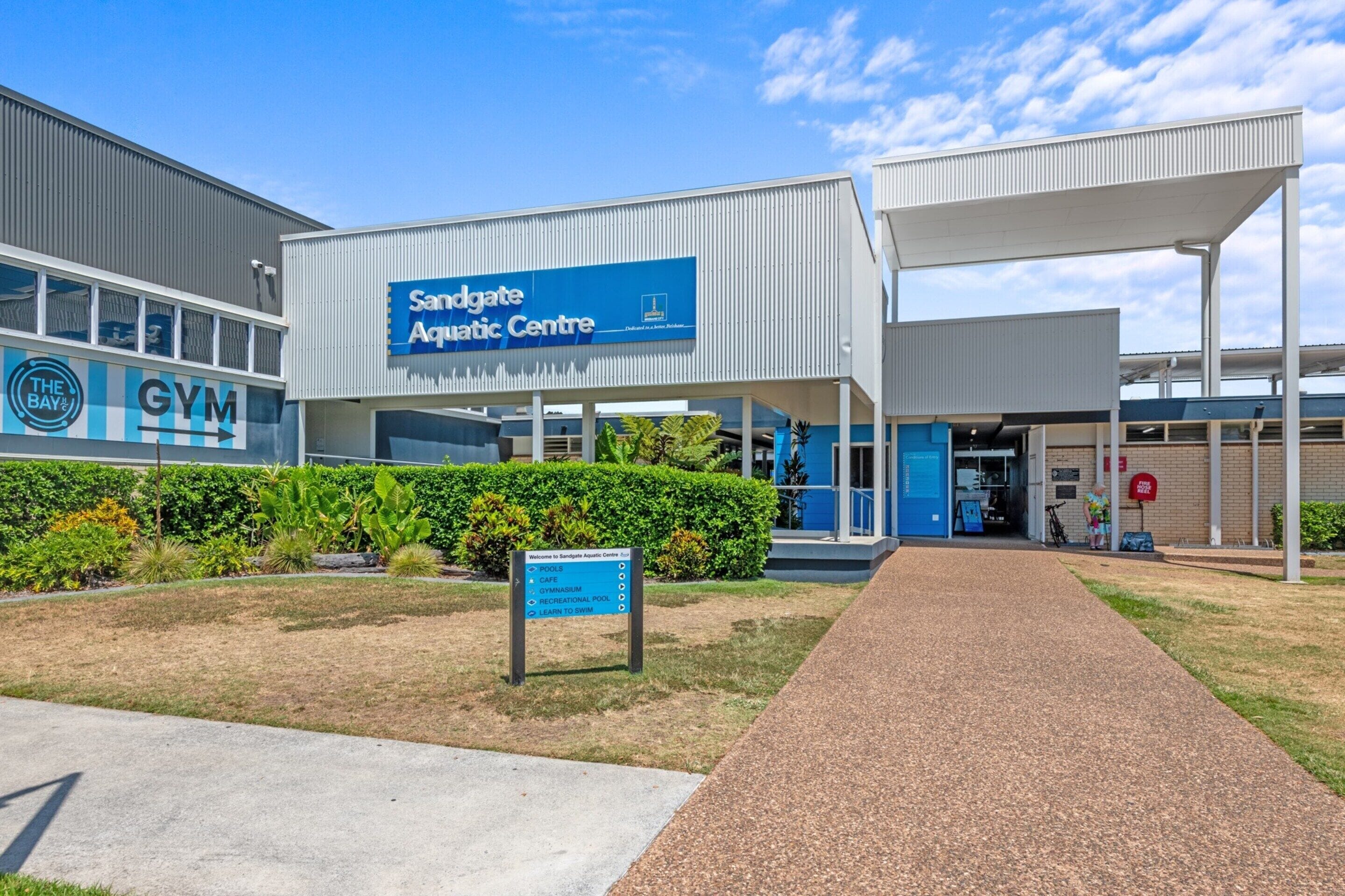 Le bâtiment du centre aquatique de Sandgate, avec un chemin dégagé menant à l’entrée.