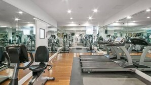 Een fitnessruimte met loopbanden, hometrainers en krachttrainingapparatuur.