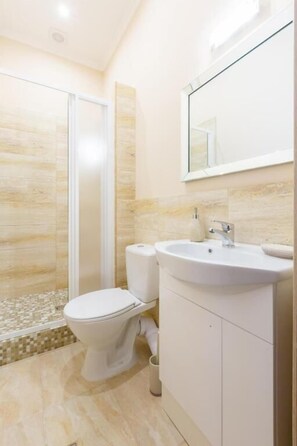 Une salle de bain moderne équipée de toilettes, d’un lavabo et d’une douche.