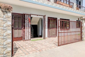 A two-story building with a stone facade, a gated entrance, and a patterned tile floor. - Hotel O Sahastradara Road Dehradun (Dehradun)
