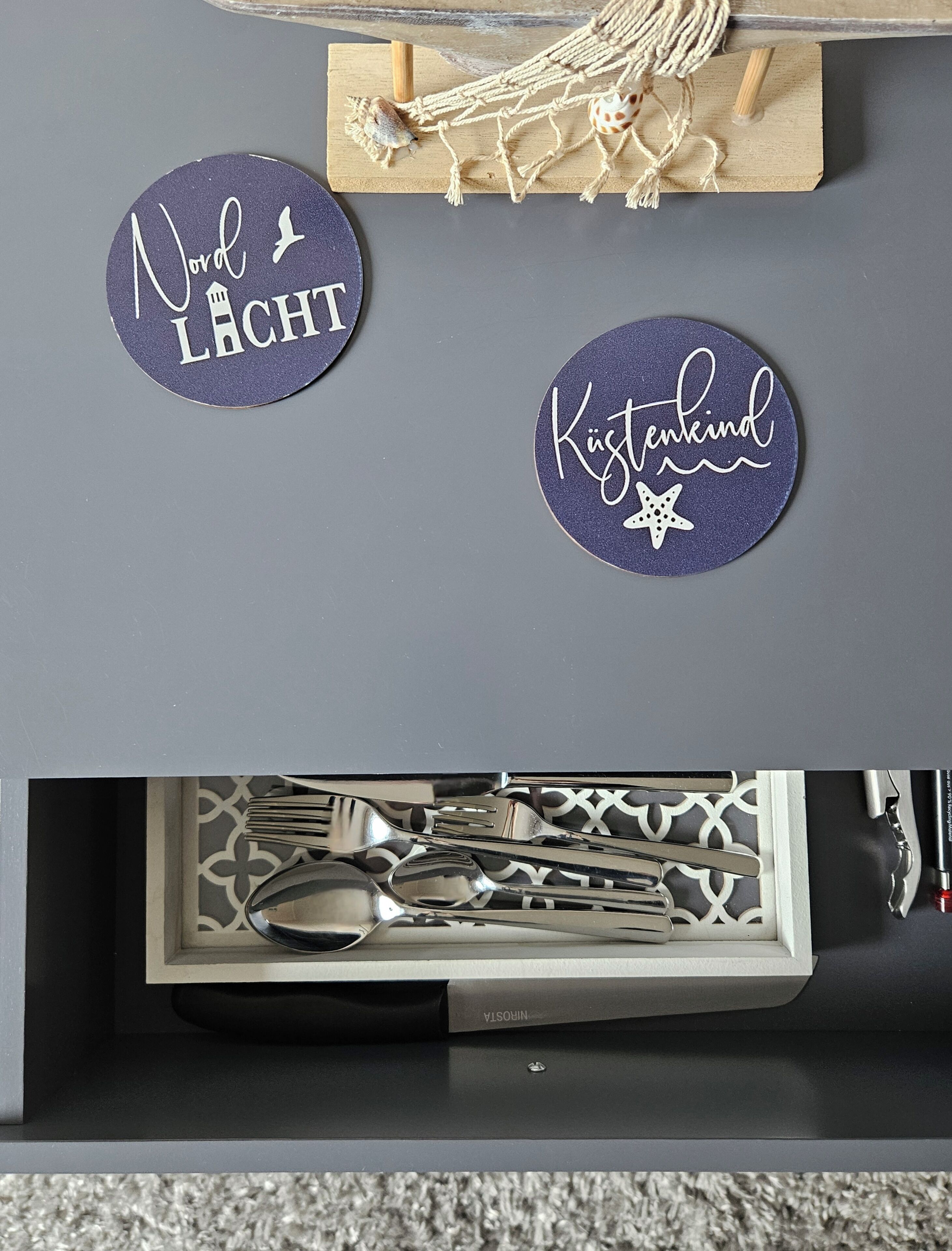 A drawer with neatly arranged cutlery including spoons, forks, and knives.