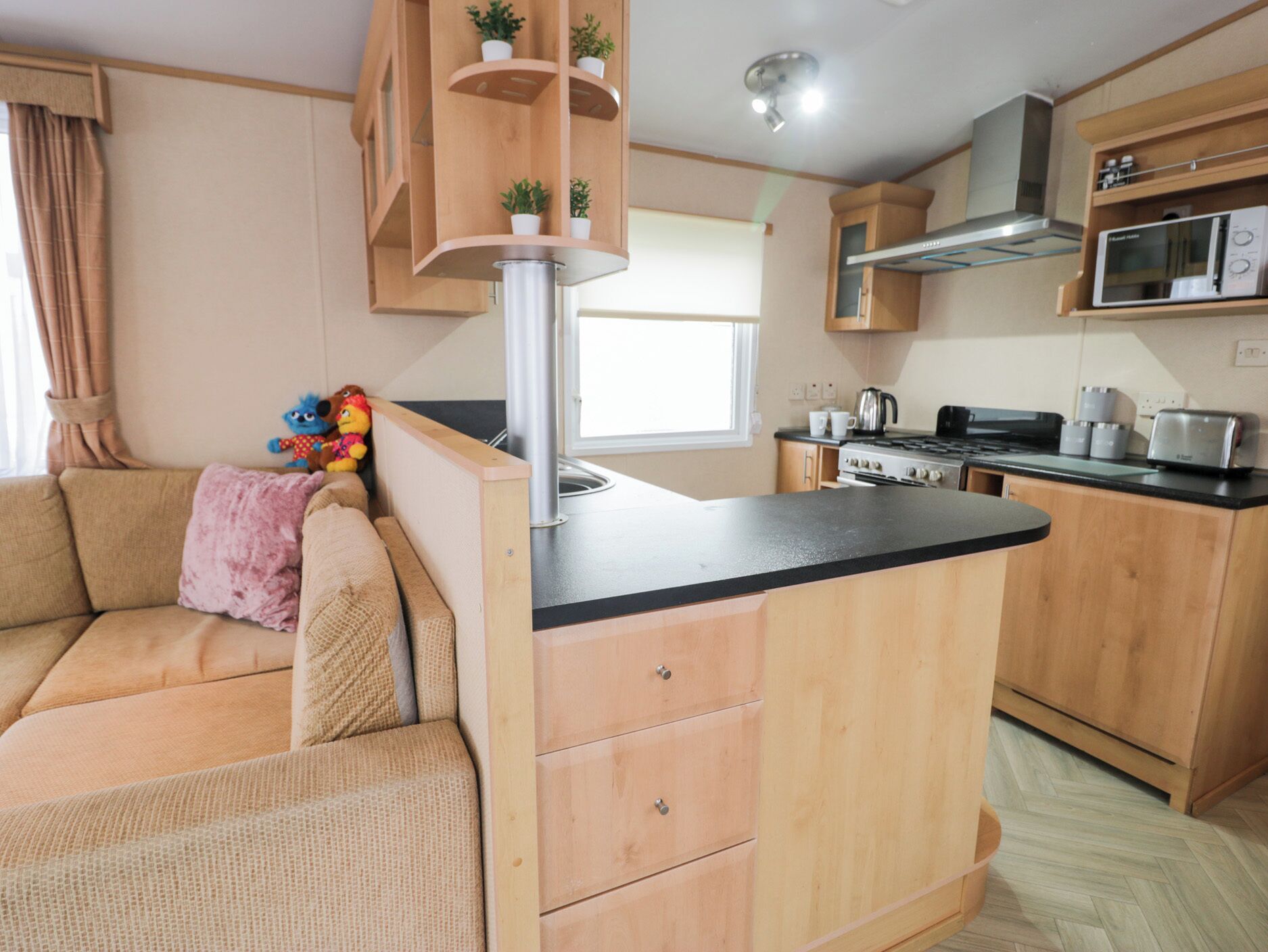 A compact kitchen with wooden cabinets, a built-in microwave, and a stove.