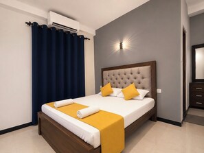 A hotel room with a bed, a nightstand, a mirror, and an air conditioning unit. - Hotel Dreamliners  (Seeduwa - Katunayake)