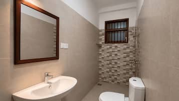 A bathroom with a sink, toilet, and shower.