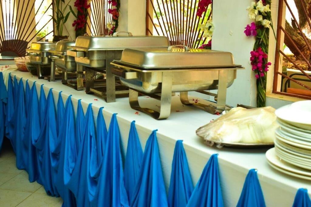 A buffet setup with multiple serving stations and a blue tablecloth.