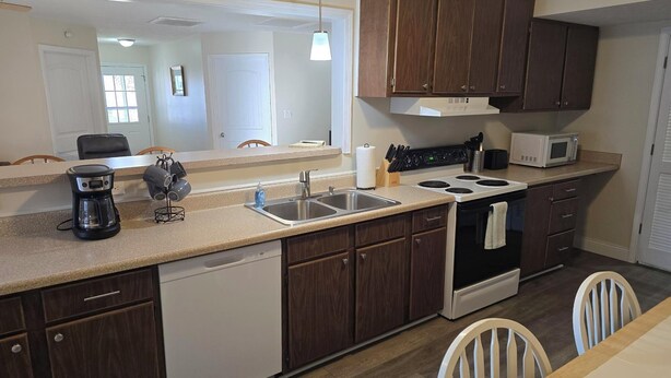 A modern kitchen with a dishwasher, double sink, stove, and microwave. - Shawnee Forest Retreat, Suite A, near Garden of the Gods, Southern IL (Harrisburg)