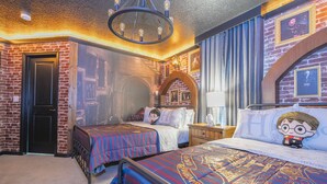 Ein thematisch gestaltetes Hotelzimmer mit Backsteinwand, einem Chandelier und passender Bettwäsche.