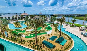 Un resort con piscina, campo de golf y vistas a un puente.