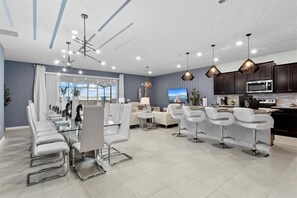 A modern kitchen with dark cabinets, a microwave, and a stove. - Last Minute Disney! Private Pool, Hot Tub, Game Room & Themed Bedrooms. Book Now! #WIR441 (Orlando)