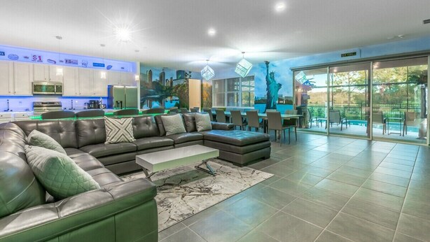 Una sala de estar moderna con un sofá modular, un comedor y una cocina.