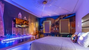 Una habitación de hotel moderna con una cama grande, un mural de paisaje urbano y una zona de piscina.